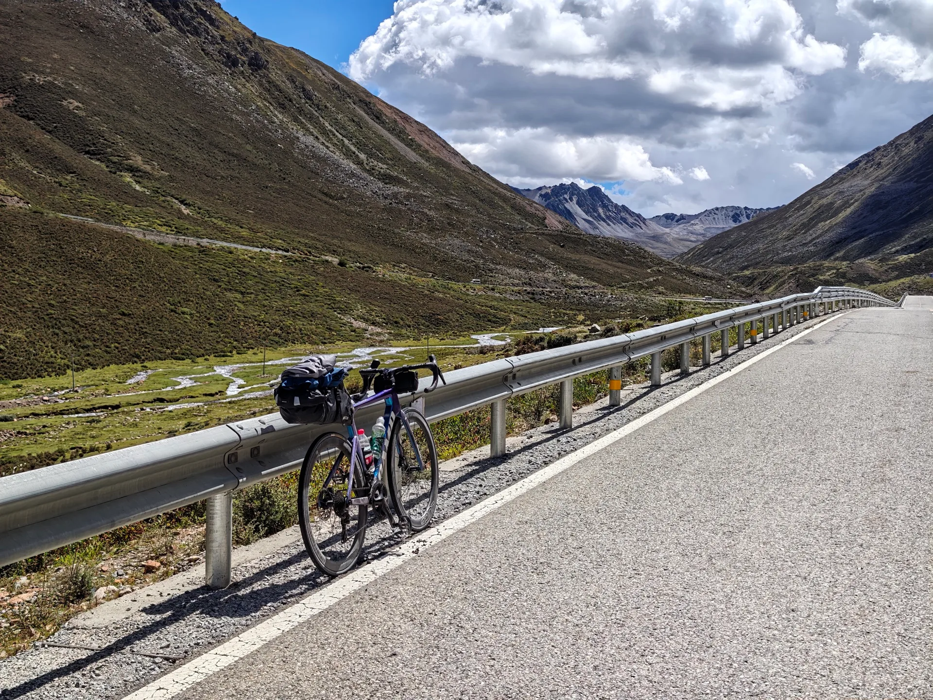 Loaded touring bicycle beside a high-altitude road