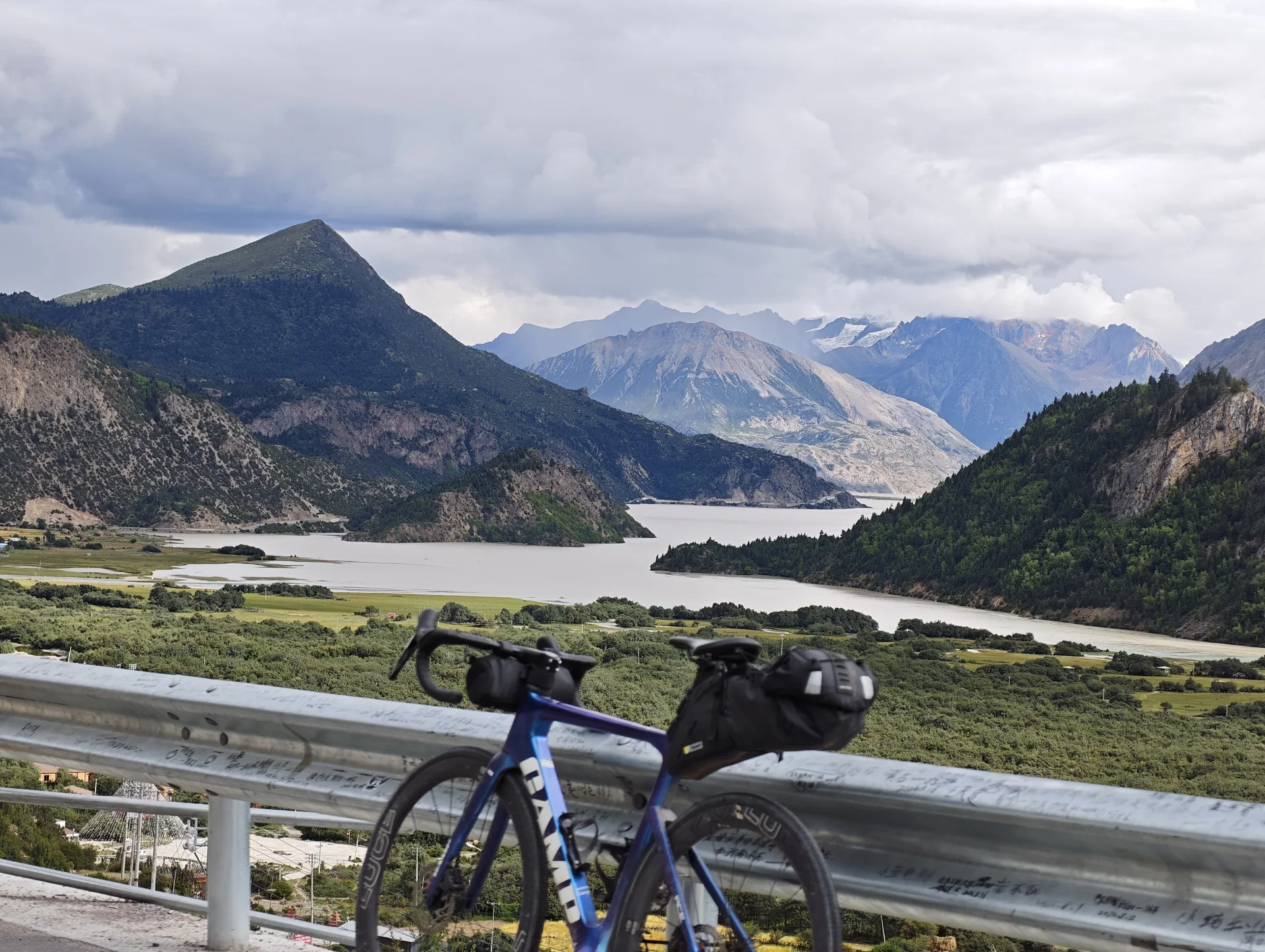 A bicycle overlooking a braided river and snow-capped mountains