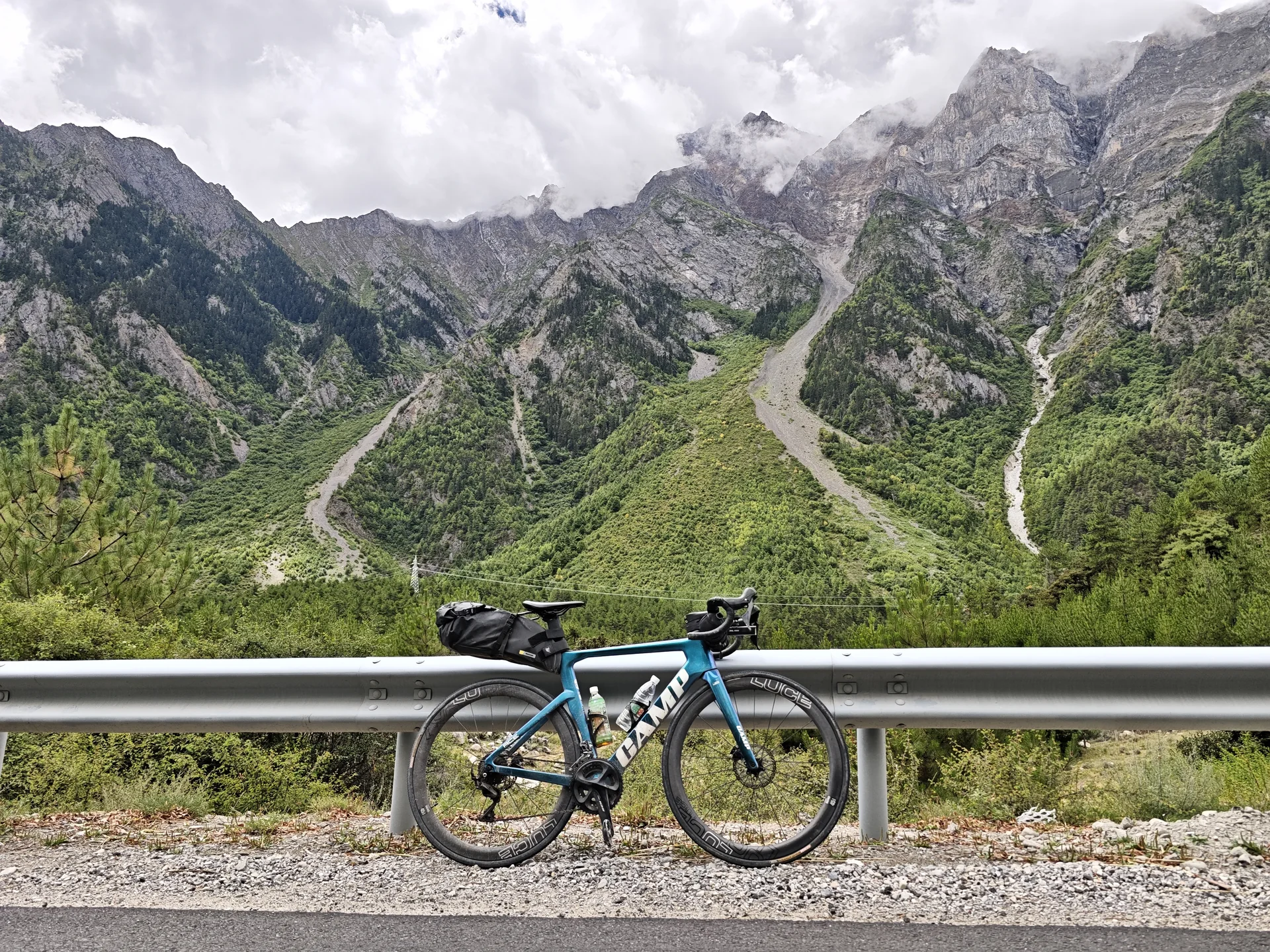 A bicycle beside a guardrail in a steep alpine valley