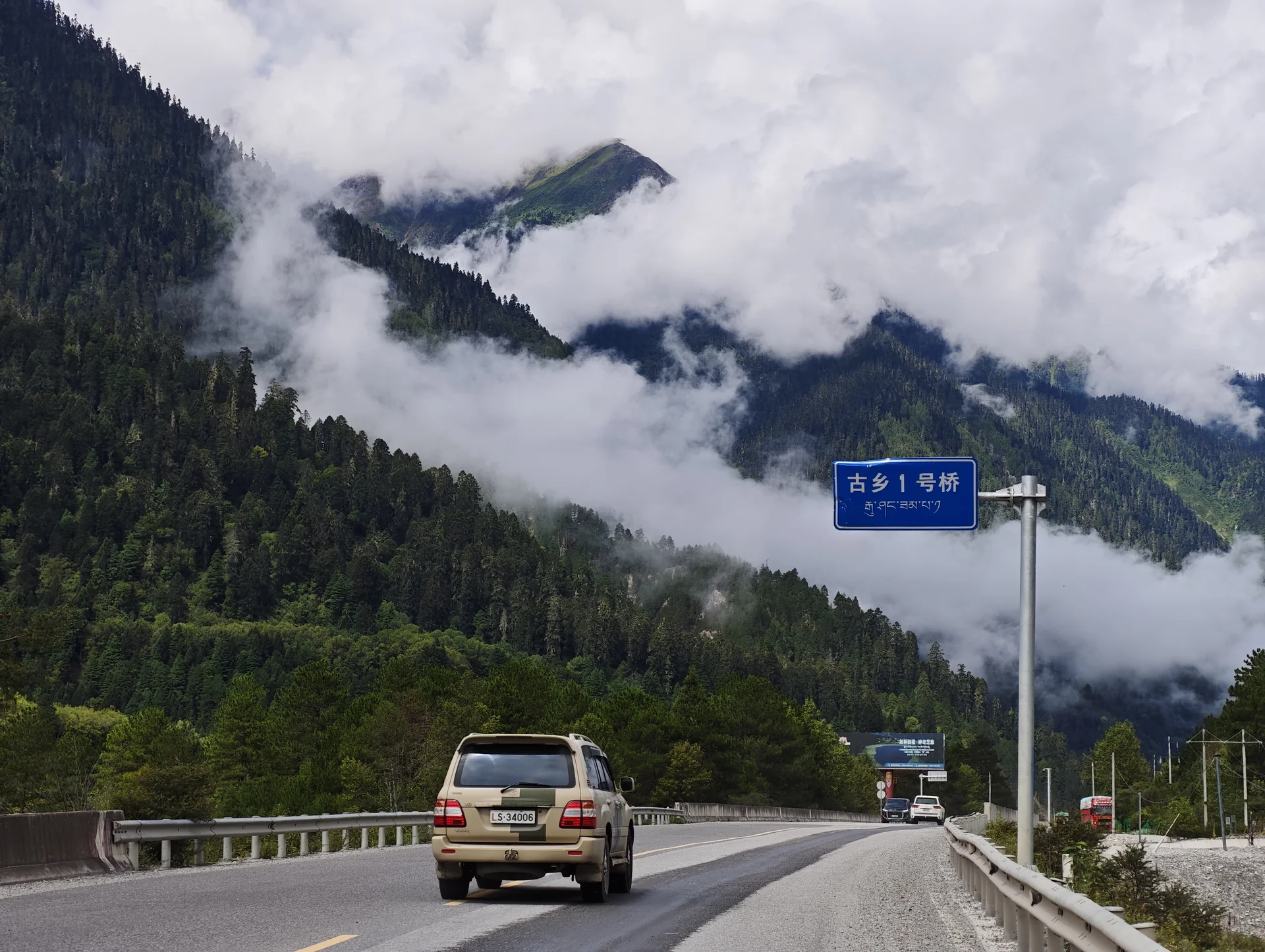 Cars traveling through a cloud-covered mountain valley