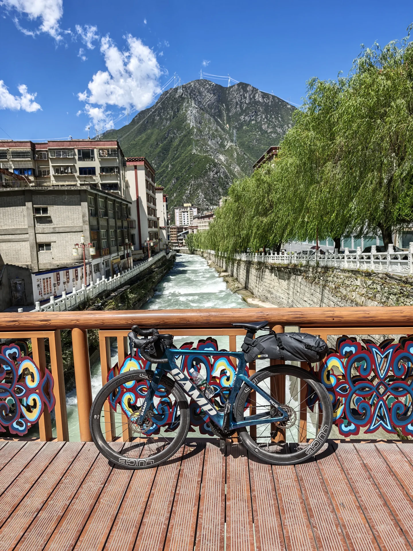Touring bicycles parked on a bridge overlooking a mountain town