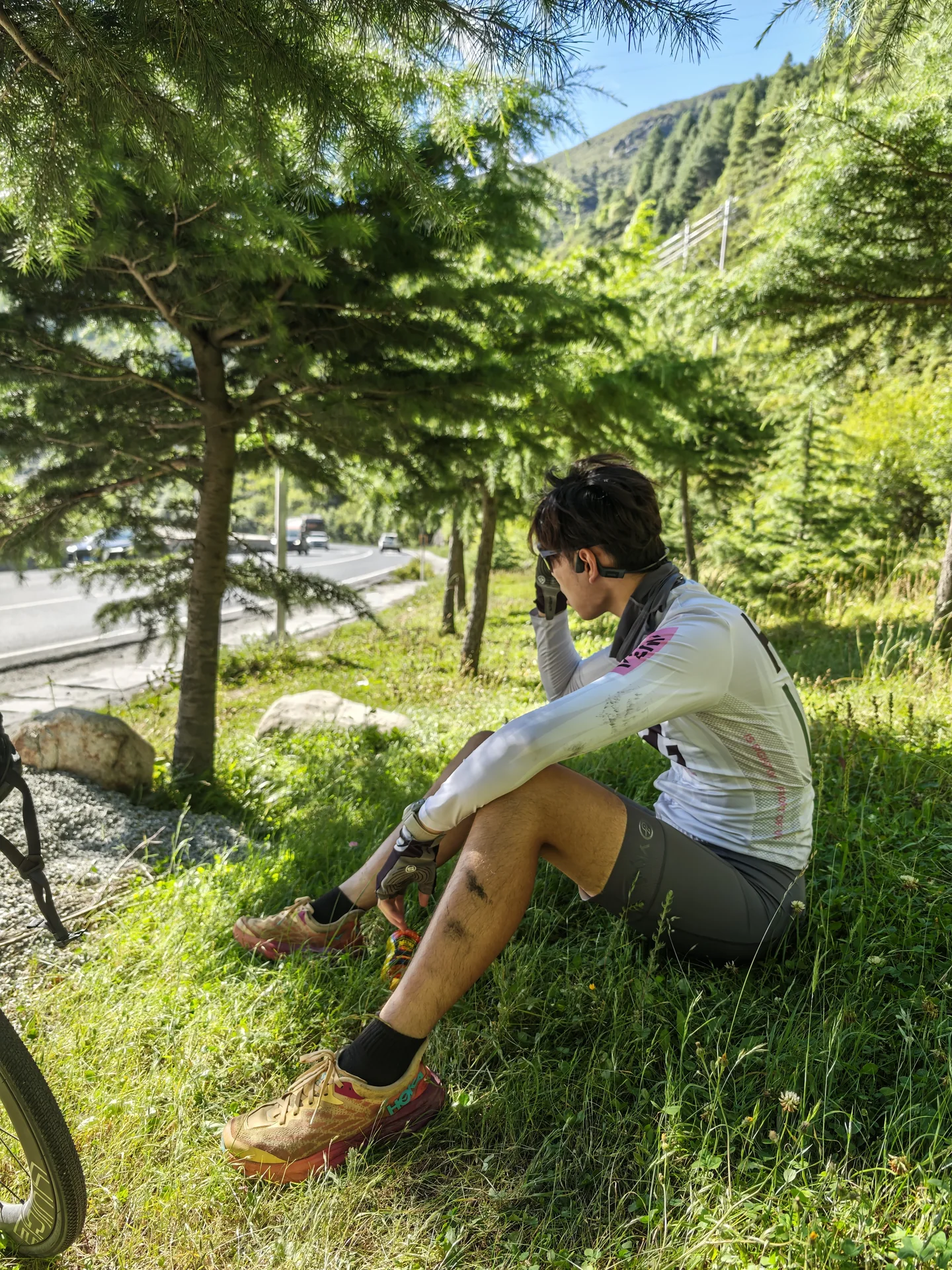 A traveler resting in the grass under trees
