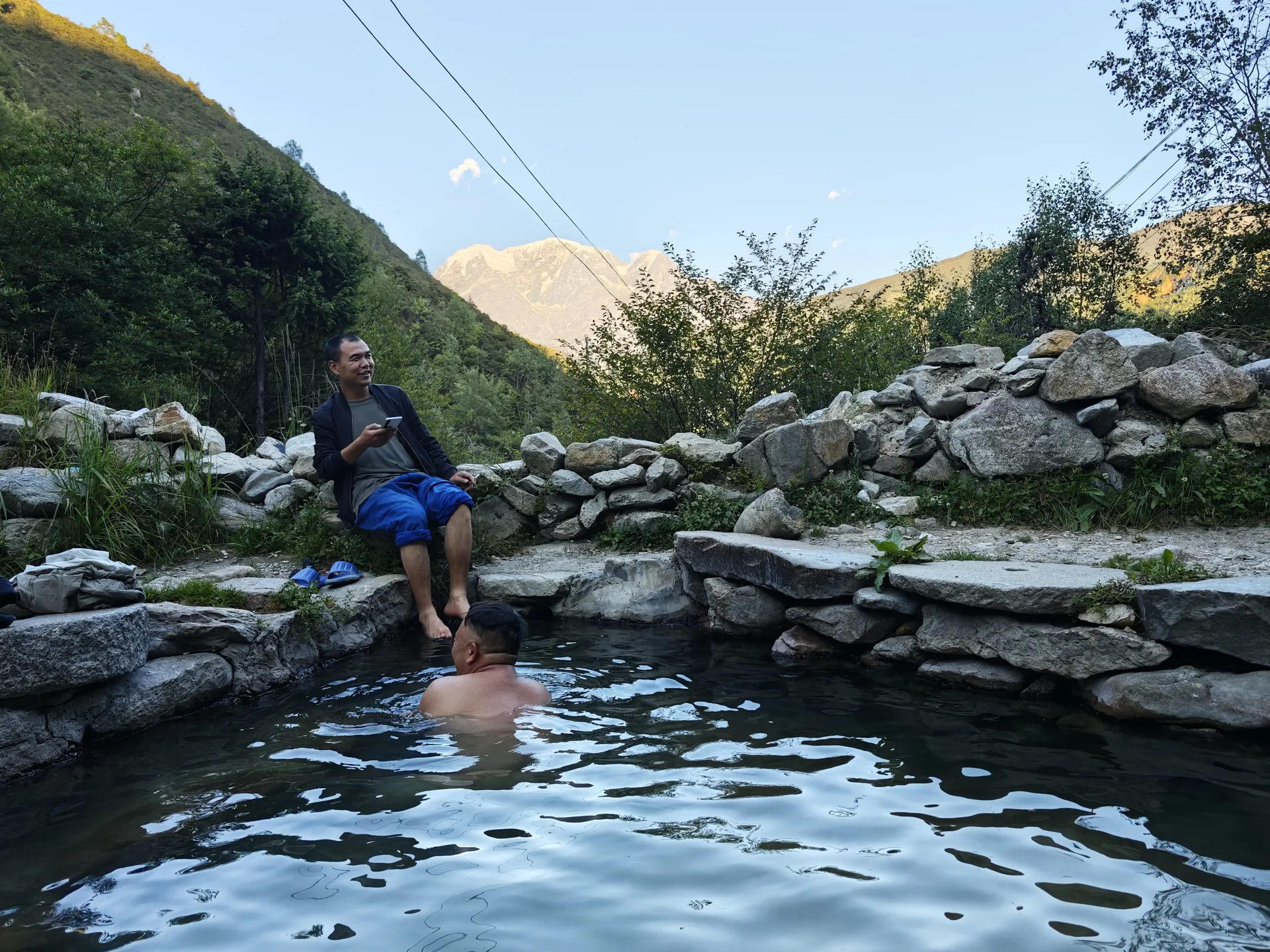 A traveler relaxing beside a mountain stream