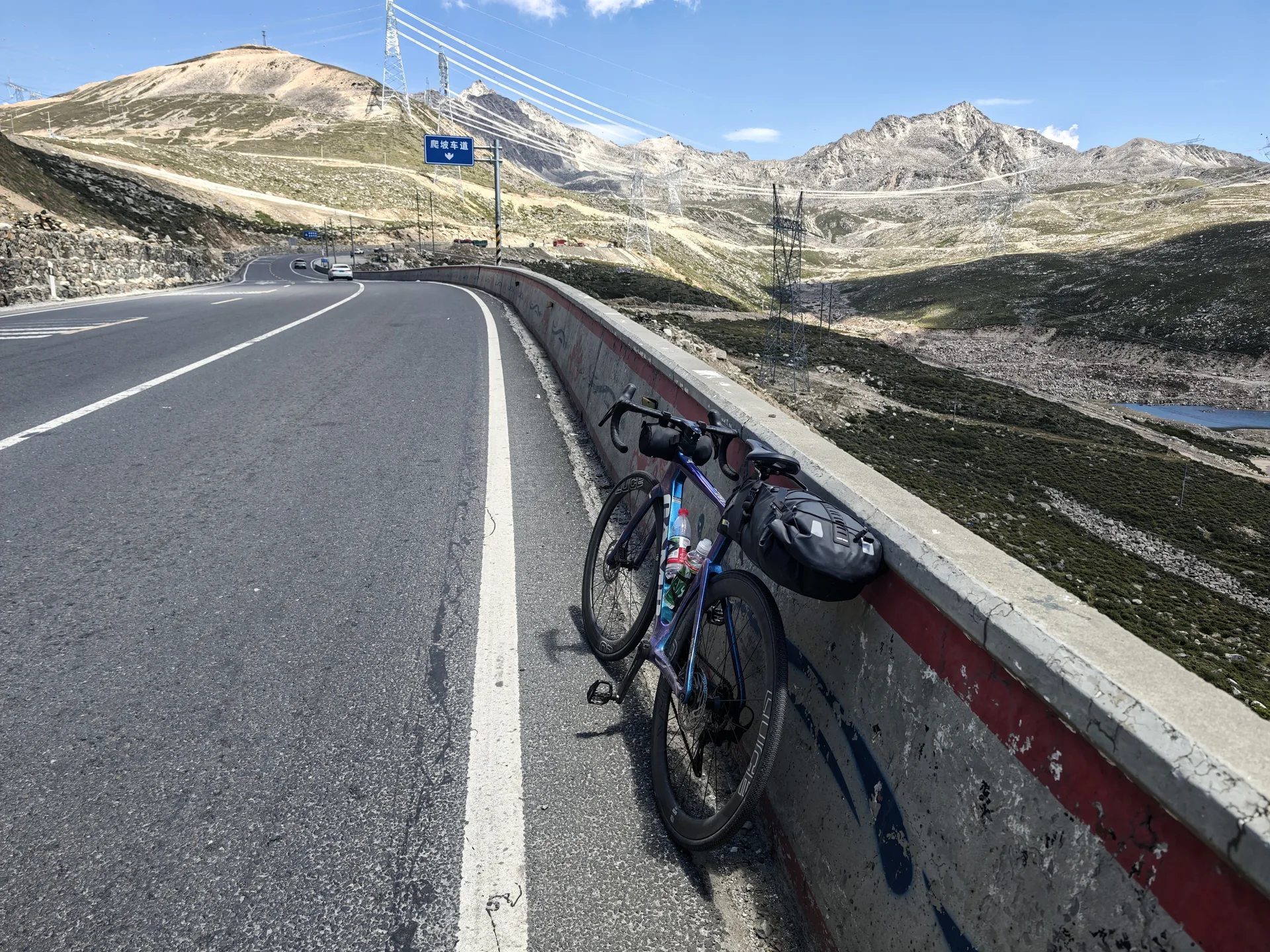 A loaded touring bicycle beside a high-altitude road
