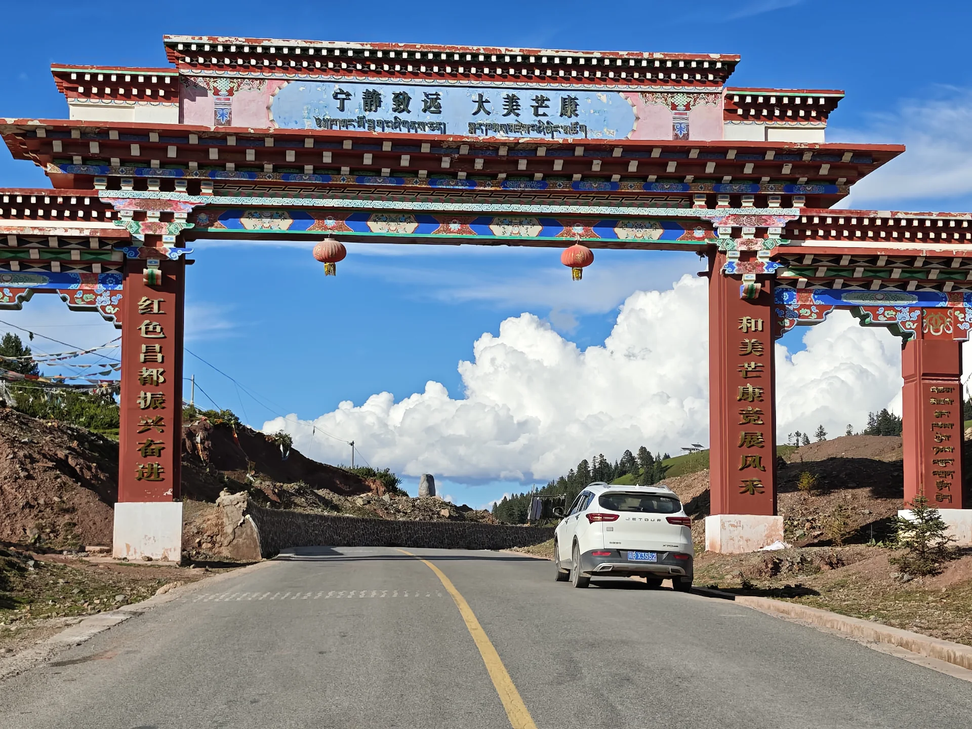 A car passing through a Tibetan-style gateway