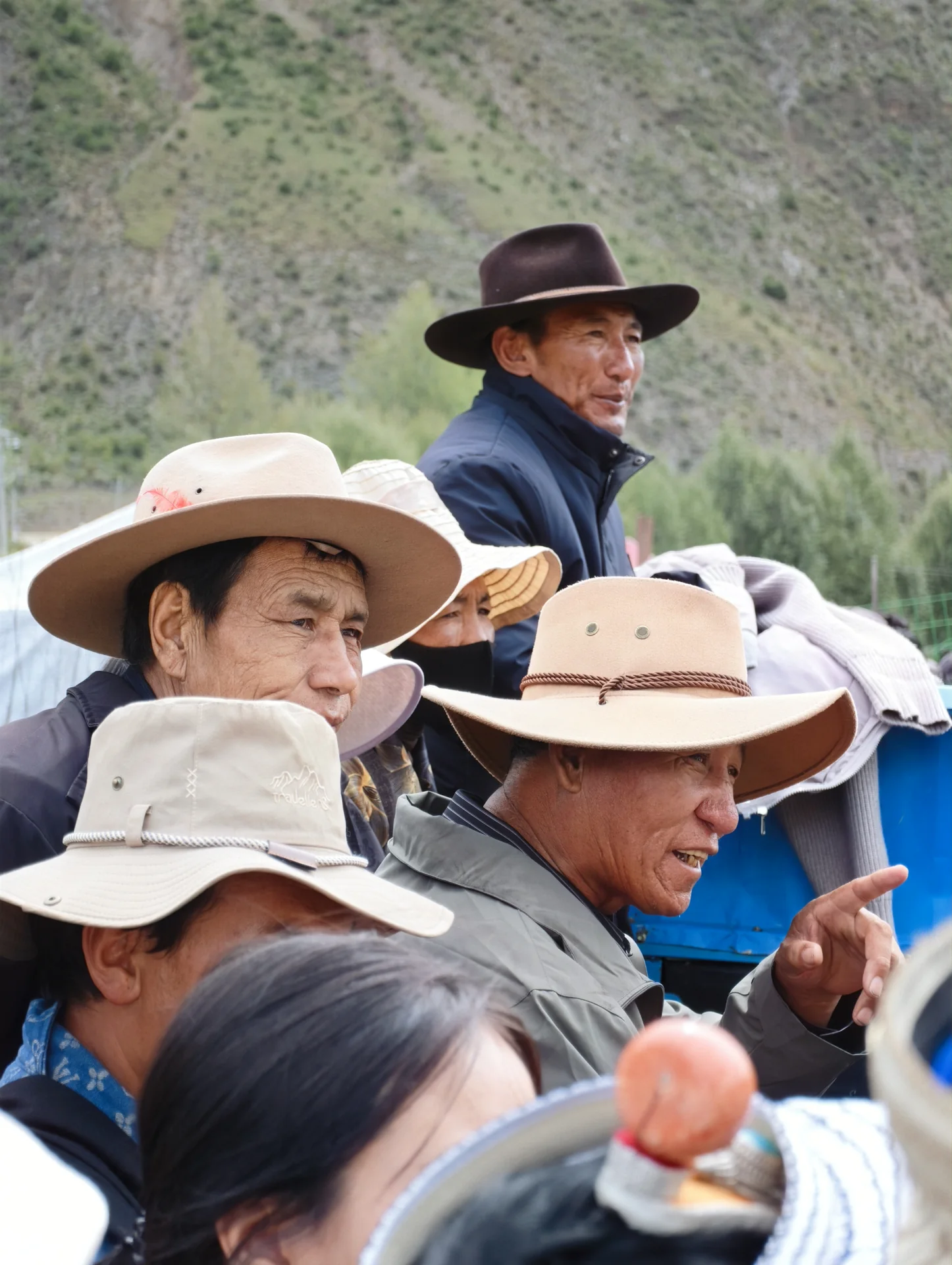 Spectators in wide-brimmed hats at an outdoor event