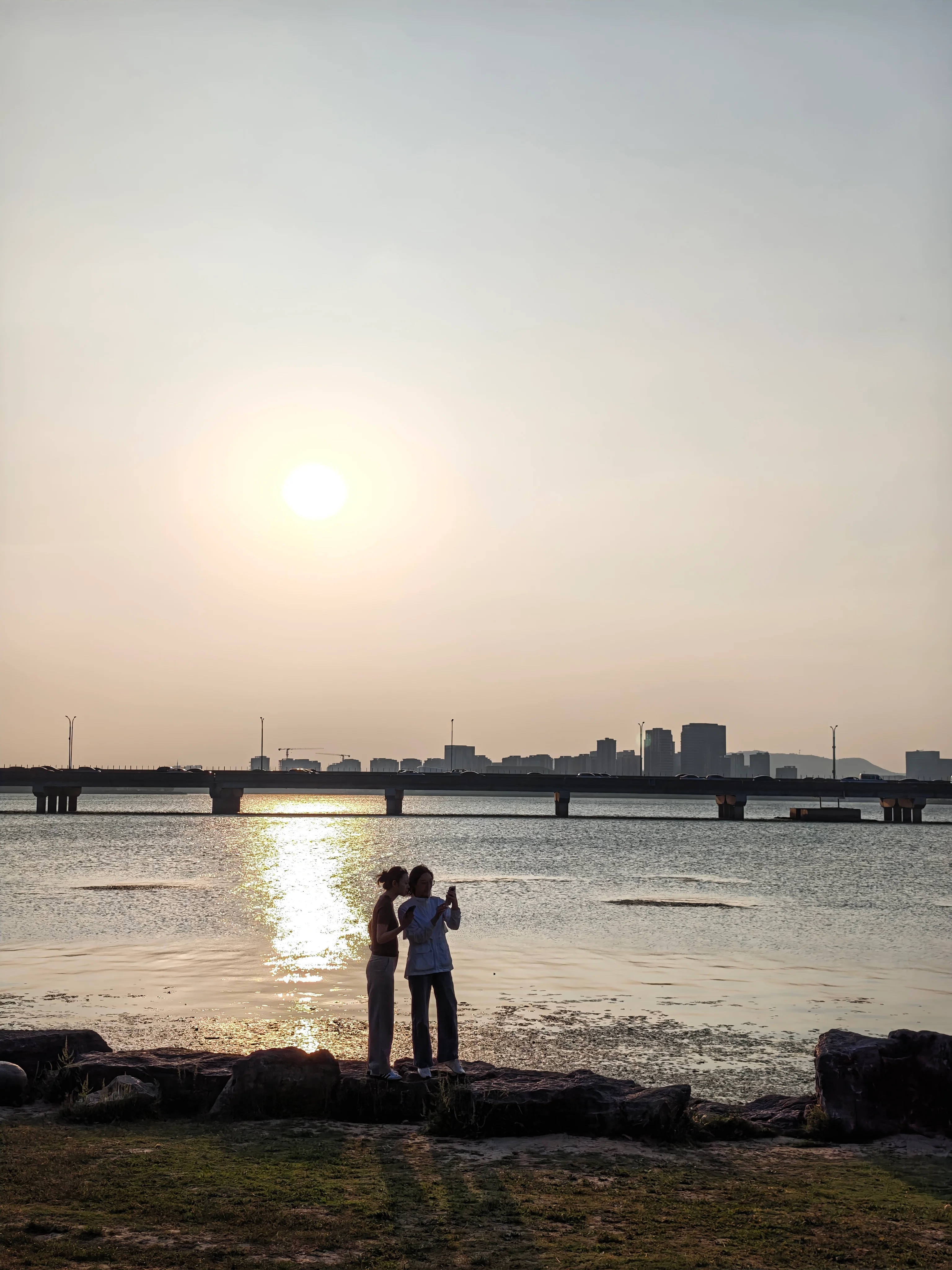游客站在太湖夕阳的倒影前