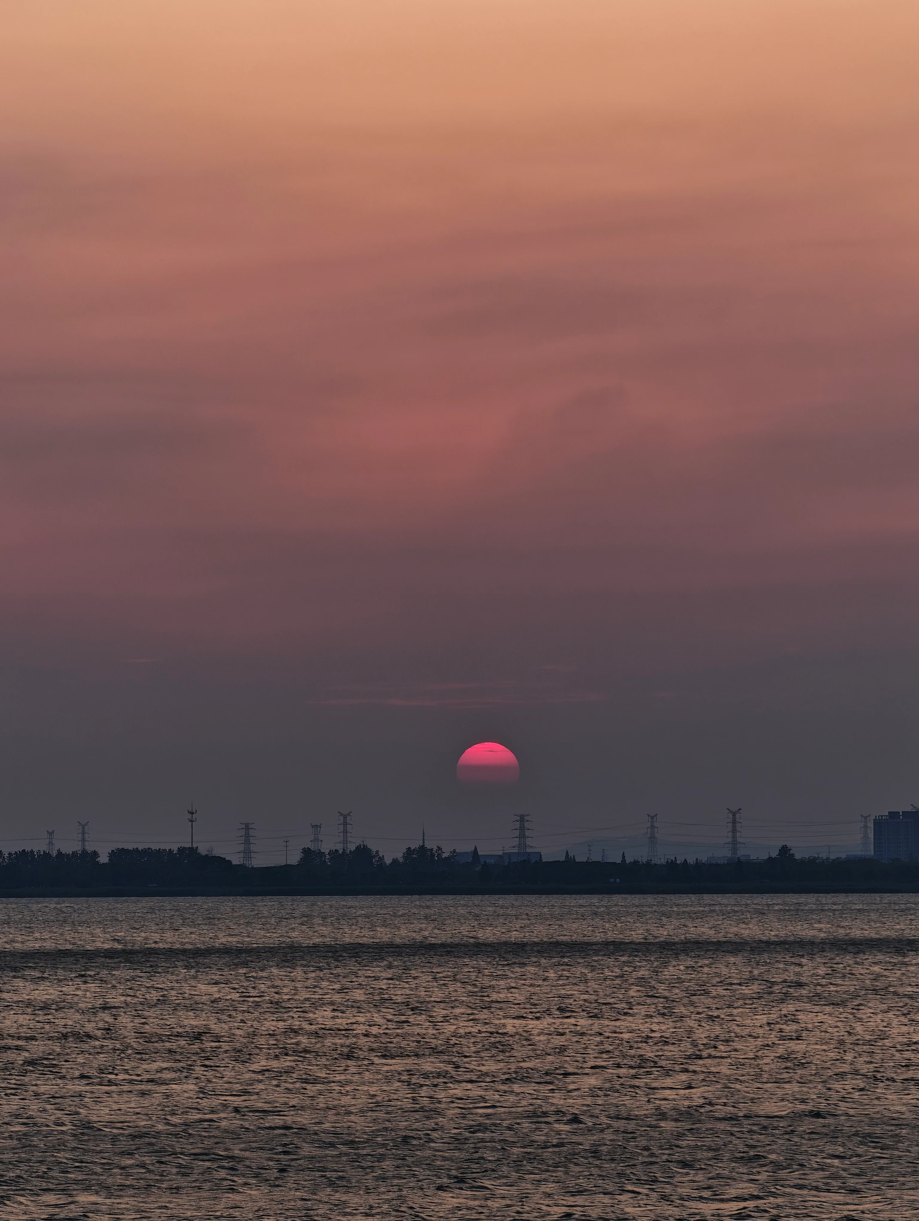 暮色中沉向太湖水面的落日