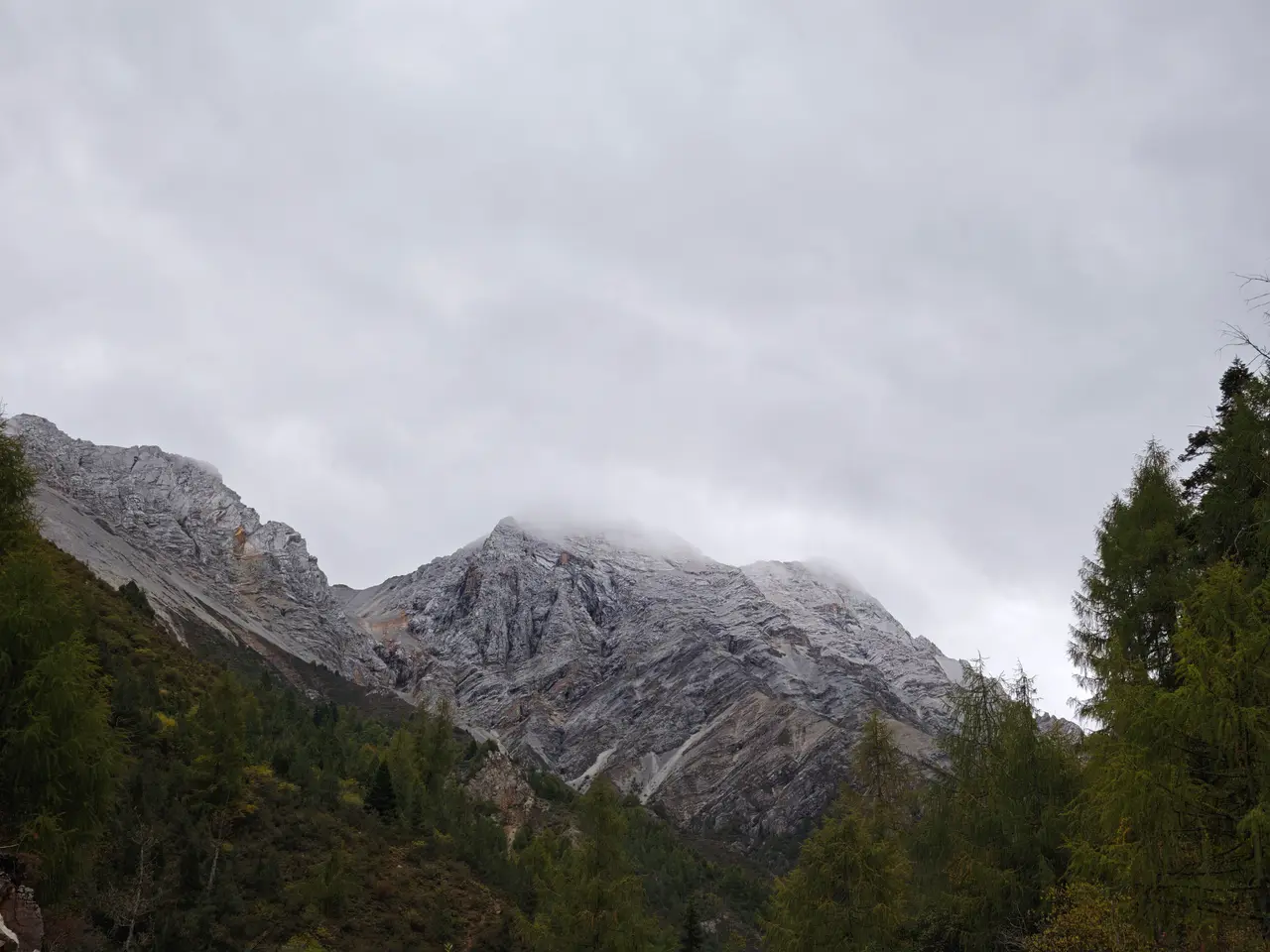 低云贴着灰白岩壁掠过，山谷在冷色光线里显得安静而空旷。